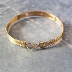 "A bold, substantial bracelet handcrafted with ten strands of 14kt gold filled wire in a classic wire-wrap style. Three strands of twist wire on each side, flanking four strands of plain square wire in the middle. Dress it up or down--it's definitely a wear-with everything accessory! Also stackable with so many of my other bracelet styles. There's nothing like an armful of affordable gorgeousness to make you feel great! The built-in hook and eye-type clasp is easy to get on and off. This bracele Artisan Wire Wrapped Adjustable Bracelets, Artisan Adjustable Bangle Bracelets, Adjustable Hand-strung Wrap Bangle, Handmade Adjustable Gold Wrap Bracelet, Adjustable Gold Wrap Bracelet, Gold Adjustable Wrap Bracelet, Adjustable Artisan Jubilee Bracelet, Artisan Wire Wrapped Bracelets, Adjustable Hand-strung Bangle Jewelry