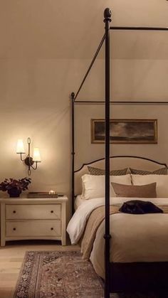 a bedroom with a four poster bed and white walls