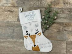 a white christmas stocking with a deer on it and the words baby's first christmas