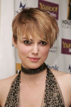 a close up of a person wearing a halter neck dress and choker necklace