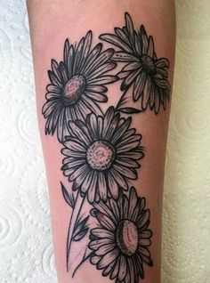 a woman's leg with flowers on it and the caption reads, fineline blackwork bunch of daisies tattoo by gurra