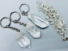 three clear crystal pieces are sitting next to each other on a silver keychain