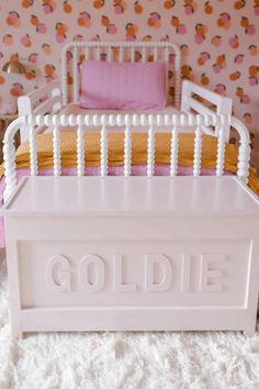 a white doll bed with the word goldie on it