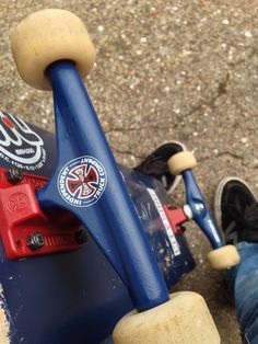 a person riding a skateboard on top of cement floored ground with their feet propped up against the board