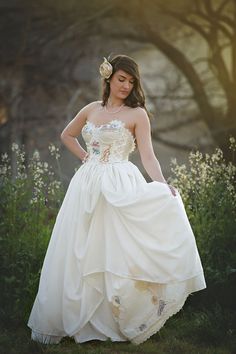 a woman in a white wedding dress posing for the camera with her hands on her hips