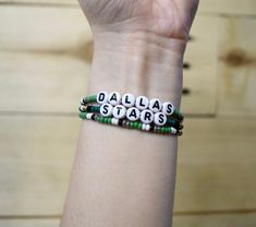 Cheer on the Dallas Stars with our stars-inspired bracelet stack. Bracelets make the perfect gift for a Stars fan. Our bracelet set includes three bracelets: two bracelets inspired by the team's victory green jerseys and a retro inspired stars' bracelet.  Looking for another NHL team, shop our other NHL inspired bracelets here:  https://www.etsy.com/listing/1441237068/nhl-inspired-bracelets-hockey-bracelets  https://www.etsy.com/listing/1521242556/retro-nhl-inspired-bracelets-hockey  Each bracelet features 8/0 glass seed beads & acrylic letter beads on nylon cord, with a sliding knot closure.  Bracelets are available in multiple sizes:  6 Inches (X-Small) 6.5 Inches (Small) 7 Inches (Medium) 7.5 Inches (Large)  8 Inches (X-Large)  If you need a size that is not listed, please message me wi Star-shaped Letter Beads Bracelets For Gift, Star-shaped Letter Beads Bracelets As Gift, Star-shaped Letter Beads Bracelet As Gift, Star Shaped Letter Beads Bracelets For Gifts, Hockey Bracelet, Stars Bracelet, Minnesota North Stars, Inspired Bracelets, Stack Bracelets