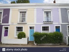 multi - colored houses in the uk with white trim and blue doors, on a sunny day