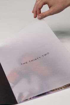 a person holding up a piece of paper with the word the thirty two on it