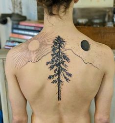 a man's back with a pine tree tattoo on it