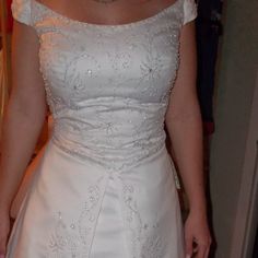 a woman in a white wedding dress is holding her hand on her hip and looking at the camera