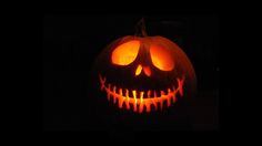 a jack o lantern pumpkin lit up in the dark