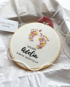 an embroidery kit with a baby's footprints and name on it