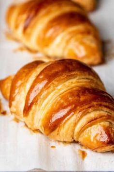 two croissants sitting on top of a baking sheet next to each other