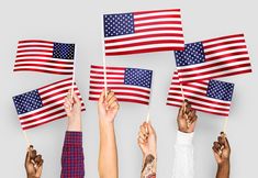 many people holding american flags in their hands