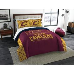 a bed with a maroon and yellow comforter