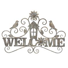 a metal welcome sign with two birds on it