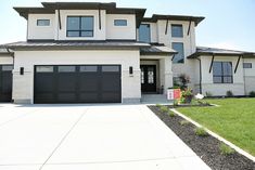 a large white house with black garage doors