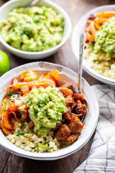 two bowls filled with rice, meat and veggies on top of a wooden table