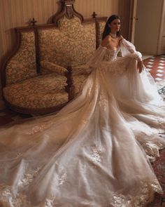 a woman in a wedding dress sitting on a couch with her hand on her hip