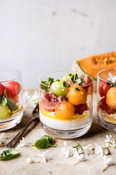 three small glasses filled with fruit on top of a table