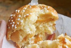 a close up of a person holding a doughnut with white sprinkles