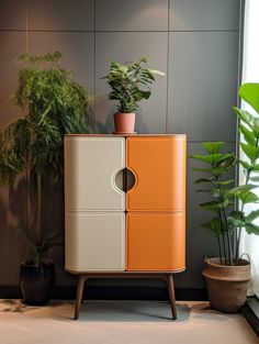 an orange and white cabinet next to potted plants