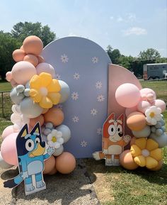 balloons are arranged in the shape of animals and flowers on display at an outdoor event