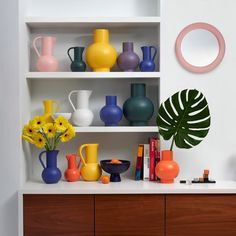 vases, books and other decorative items are displayed on shelves in a room with white walls