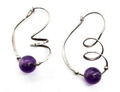 Amethyst purple beaded Artisan sterling silver twisted spiral vintage hoop earrings. Good used condition with little to no signs of normal wear. Beautiful purple amethyst beads have two small sterling silver beads on each side of the stone. Beautiful artisan sterling twist on the face of the hoop. Acid tests positive for sterling silver. Gemstone tested with Presidium II Gemstone tester. Earring measure 1 and 1/4 of an inch tall and 7/8ths of an inch deep. Handmade Swirl Jewelry With A Modern Twist, Handmade Sterling Silver Earrings With A Modern Twist, Handmade Purple Spiral Jewelry, Amethyst Beads, Amethyst Purple, Sterling Silver Bead, Purple Amethyst, Silver Beads, The Stone