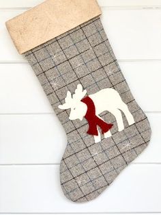 a christmas stocking with a reindeer on it and a red scarf hanging from the side