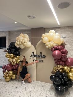 a woman posing in front of an arch made out of balloons with the name ambella on it