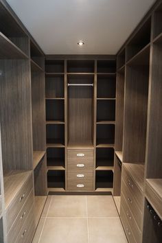 an empty walk in closet with drawers and shelves