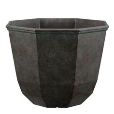 a large black planter sitting on top of a white wall