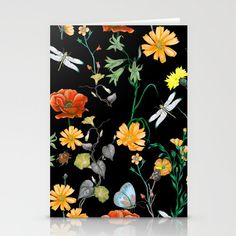 a greeting card with flowers and dragonflies on black, featuring yellow daisies and red poppies