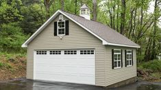 a two car garage in the middle of a wooded area