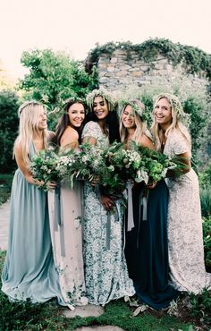 a group of women standing next to each other holding flowers and greenery in their hands