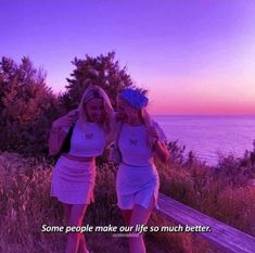 two young women standing next to each other near the ocean with a quote on it