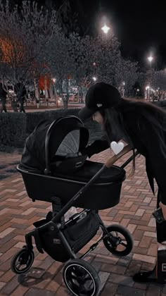 a woman bending over to pick up her baby's stroller