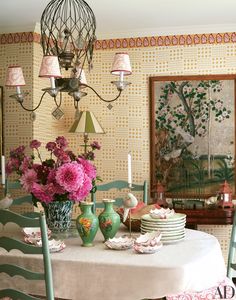 a dining room table with plates and vases on it