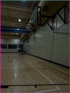 an indoor basketball court with hard wood flooring