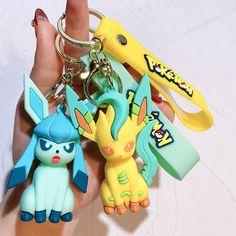 the pokemon keychains are being held in someone's hand