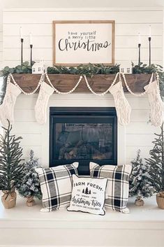 a fireplace decorated for christmas with greenery and stockings on the mantel above it