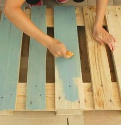 a person is making something out of pallets on the ground with their hands and feet