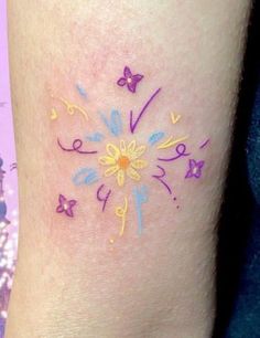 a colorful tattoo on the leg of a woman with butterflies and flowers painted on it