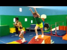 two girls are jumping in the air on trampoline mats at an indoor gym