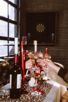 two people toasting with wine glasses on a table