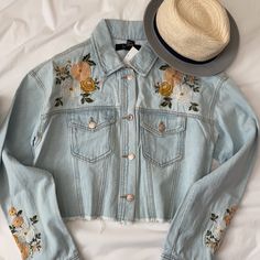 Pretty Floral Embroidered Denim Jacket In A Light Wash. 100% Cotton. Cropped Raw Him. Fit Is Loose But Not Oversized. Very Cute For A Festival Look. Wear With Cut-Off Shorts And Cowboy Boots! Please Excuse The Light Coming In From The Window, There Is No Discoloration On Item. Trendy Floral Embroidered Denim Jacket For Spring, Casual Embroidered Denim Jacket For Summer, Embroidered Long Sleeve Denim Jacket For Summer, Embroidered Casual Denim Jacket For Summer, Embroidered Long Sleeve Summer Denim Jacket, Spring Light Wash Long Sleeve Denim Jacket, Summer Outerwear With Floral Embroidery In Medium Wash, Long Sleeve Denim Jacket For Spring Day Out, Spring Denim Jacket For Day Out