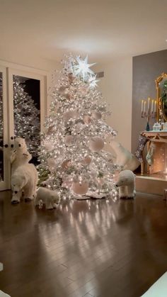 a white christmas tree sitting on top of a hard wood floor