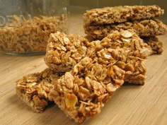 three granola bars stacked on top of each other next to a jar of oatmeal