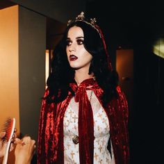 a woman dressed in red and white holding a toothbrush next to another woman with black hair